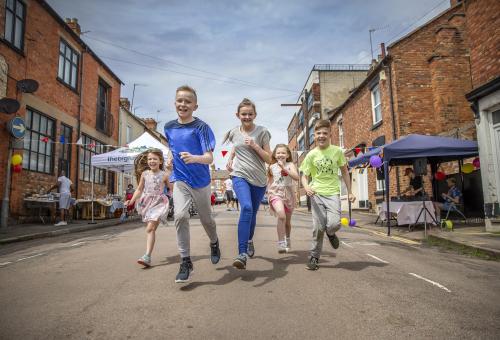 Children running down an open street